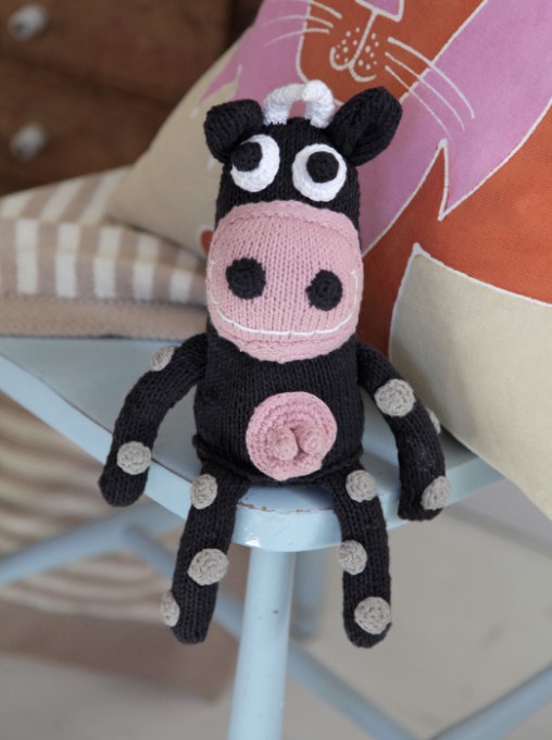 Knitted cow in pastel pink and pastel pink cushion